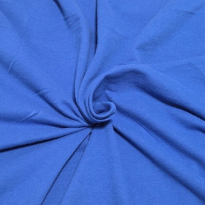 May include: Close-up of a vibrant blue fabric with a soft texture. The fabric is gathered and folded, creating a swirling pattern. The color is a rich, solid blue, with subtle variations in tone due to the folds and shadows.