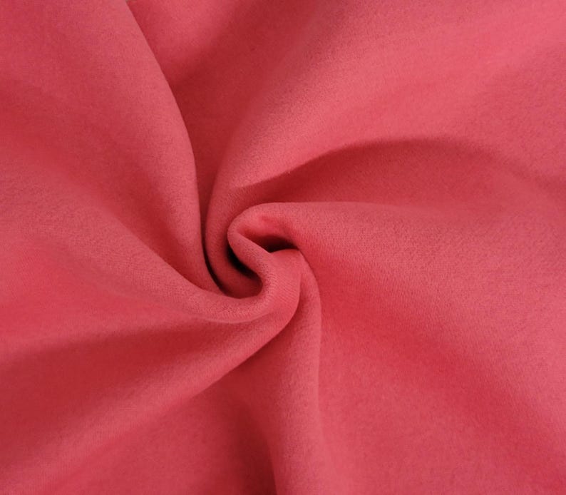 May include: A solid, deep rose-pink fabric with a soft, matte texture. The material is gathered in the center, creating natural folds and shadows that highlight the consistent, uniform color and the smooth, non-reflective surface of the textile.