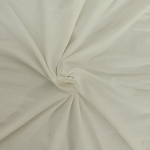 Puede incluir: Una tela de color blanco roto s&oacute;lido con una textura suave y mate, reunida en el centro para crear pliegues y drapeados suaves y radiantes que se extienden hacia afuera por todo el marco, mostrando el color crema claro y la superficie textil.