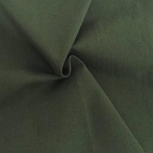 May include: A solid dark olive green fabric with a smooth, matte texture. The material is draped to create soft, flowing folds and shadows, highlighting the consistent deep green color and the fine, uniform weave of the textile surface.