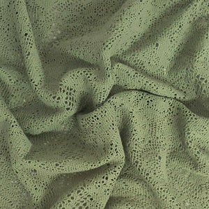 May include: A close-up of a sage green crocheted fabric with a textured, open-weave pattern.