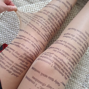 May include: Beige sheer tights featuring printed text in dark grey, covering the entire surface. A bird silhouette is near the top of one leg. These tights are a distinctive fashion item. The text appears to be from a poem or story.