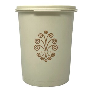 May include: A white plastic container with a brown floral design. The container has a lid and is perfect for storing food.
