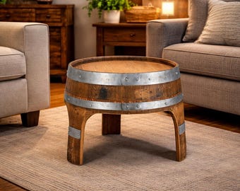 May include: A rustic, barrel-shaped coffee table made of wood and metal. The table features a round wooden top and is encircled by two metal bands. The legs are also made of wood and have metal accents. This unique piece adds a touch of vintage charm to any living space.