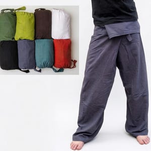 May include: A person wearing gray wrap pants. The pants have a wide leg design and a wrap-around waist. In the upper left corner, there are several folded fabric bags in various colors, including green, black, blue, and red.