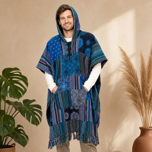 May include: A blue hooded poncho featuring a patchwork design with various geometric and floral patterns in shades of navy, azure, and teal. The garment includes a front kangaroo pocket, toggle closures at the neckline, and a fringed hemline.
