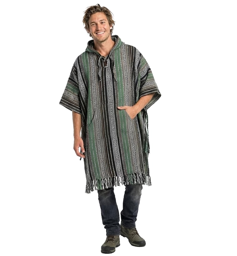 May include: A hooded poncho featuring a vertical striped pattern in shades of green, black, and white. The garment includes a front kangaroo pocket, a drawstring neckline with ties, and a fringed hemline at the bottom edge of the fabric.