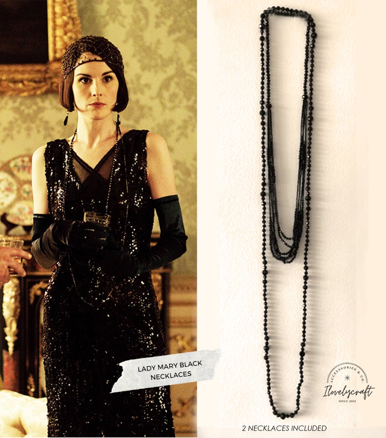 Puede incluir: Un conjunto de 12 collares de cuentas negras. Los collares est&aacute;n superpuestos y presentan un dise&ntilde;o cl&aacute;sico. El texto "Lady Mary Black Necklaces" y "12 Necklaces Included" es visible en la imagen.