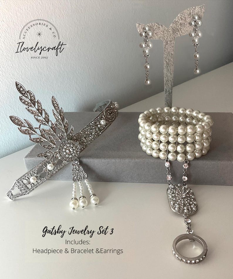 May include: Gatsby Jewelry Set 3 includes a silver headband with pearl accents, a pearl bracelet, and a pair of pearl drop earrings.