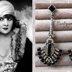 Puede incluir: Un par de pendientes largos de plata Art Deco con diamantes de imitaci&oacute;n negros y transparentes. Los pendientes cuelgan de una caja negra con el texto "I love lycraft since 2016" en ella.