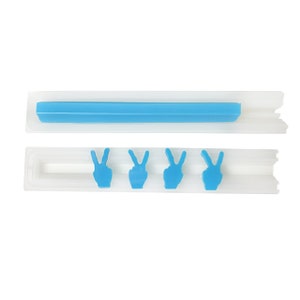 May include: A white silicone mold with four peace sign shapes. The mold is open and the peace signs are blue.