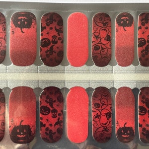 May include: A set of 10 red and black Halloween nail wraps with a gradient design. The wraps feature a variety of Halloween-themed images, including pumpkins, ghosts, bats, and skulls.