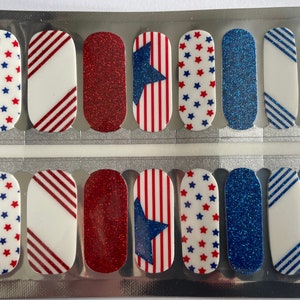 May include: A sheet of nail polish strips with patriotic designs. The strips feature red, white, and blue colors with star and stripe patterns. Some strips have glitter effects, while others have solid colors or diagonal stripes.