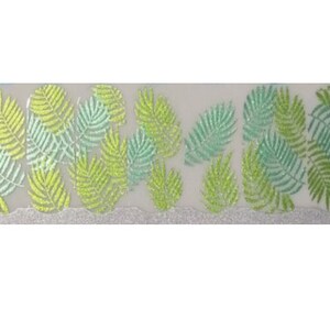 Puede incluir: Una tira decorativa con un patr&oacute;n repetido de hojas de helecho estilizadas en tonos verdes y amarillos. Las hojas tienen una textura brillante y est&aacute;n dispuestas sobre un fondo transl&uacute;cido con un borde plateado brillante.