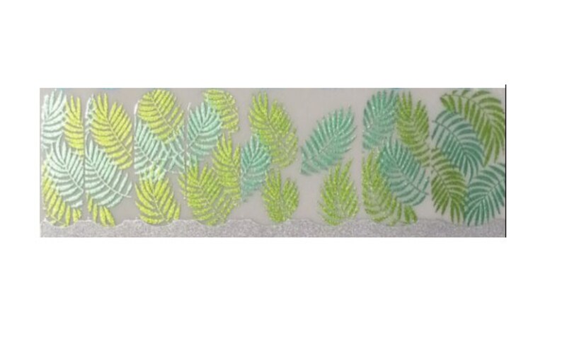 Puede incluir: Una tira decorativa con un patr&oacute;n repetido de hojas de helecho estilizadas en tonos verdes y amarillos. Las hojas tienen una textura brillante y est&aacute;n dispuestas sobre un fondo transl&uacute;cido con un borde plateado brillante.