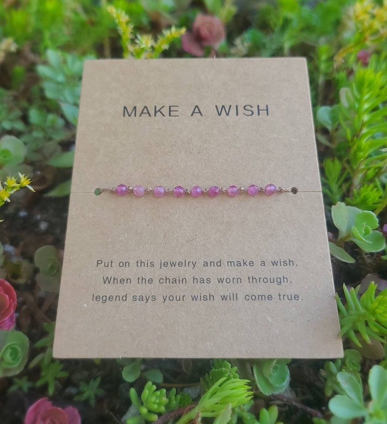 May include: A pink beaded bracelet with a gold chain. The card reads "MAKE A WISH" and says "Put on this jewelry and make a wish. When the chain has worn through, legend says your wish will come true."