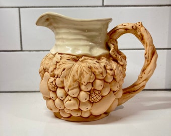 Beautiful clay pitcher glazed interior with relief of fruit on the bottom