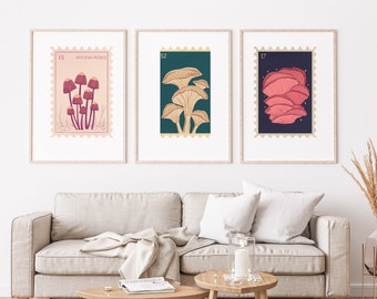 May include: Three framed prints of vintage-style mushroom illustrations. Each print features a different type of mushroom with a stamp-like border and a number in the top left corner. The first print is labeled "15 MYCENA ROSES" and features pink mushrooms. The second print is labeled "52" and features yellow mushrooms. The third print is labeled "17" and features pink mushrooms.