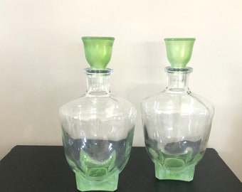 Two decanters of pressed glass, with green stopper and bottom. Square bottoms are rare, probably from the 1950s.