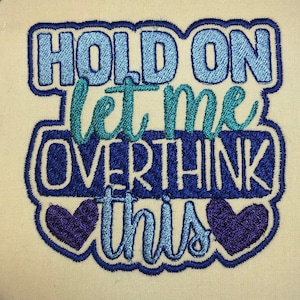 May include: Embroidered patch with blue, teal, and purple thread. The text reads "Hold on let me overthink this" with two purple hearts.
