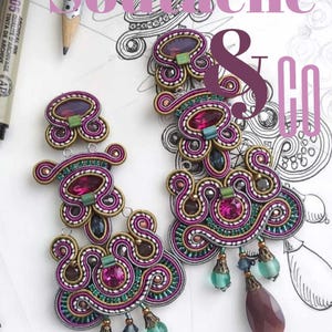 May include: Close-up of two ornate soutache earrings with magenta, teal, and gold accents. The earrings feature intricate beadwork and dangling teardrop-shaped charms. Text on the image reads "Soutache & Co" and "Alessandra del Vitto per Adelslaboratory".