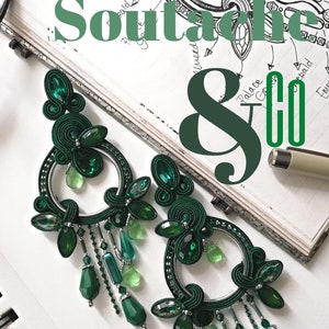 May include: Emerald green soutache earrings with dangling crystal beads. The earrings are circular with intricate woven detailing and are displayed on a notebook with text that reads "Soutache & Co".