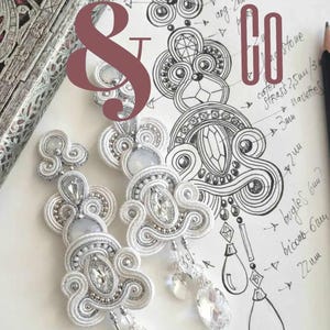 May include: Close-up of white soutache earrings with clear crystal accents, displayed next to a sketch of the design. The image includes text in Italian: "Soutache & Co" and "Creative guide with step-by-step photos and detailed descriptions."