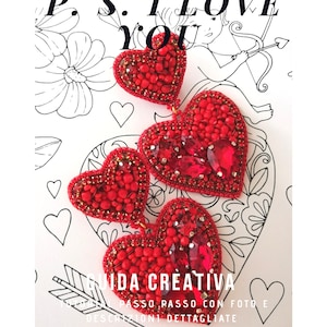 Può includere: Orecchini a forma di cuore in perle rosse con dettagli in cristallo. Gli orecchini sono sovrapposti con tre cuori, ognuno di dimensioni decrescenti. Gli orecchini sono su uno sfondo bianco con un disegno di Cupido.