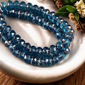 May include: A strand of dark blue faceted glass beads with a silver iridescent finish.