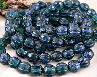 May include: A strand of dark green glass beads with blue stripes. The beads are faceted and oval shaped.