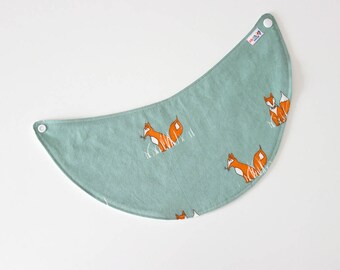 May include: A light blue baby bib with a fox print. The bib has two white snaps on the sides.