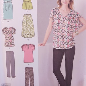 May include: A woman wearing a patterned top and black pants stands next to a pattern illustration. The illustration shows various clothing designs, including a dress, skirt, tops, and pants. The designs are in different colors and patterns.