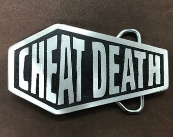 Hebilla de cinturón de metal personalizada Cheat Death con forma de ataúd. Un regalo ideal para mantener alejada a la Parca. Metal grabado. Fabricada en EE. UU.