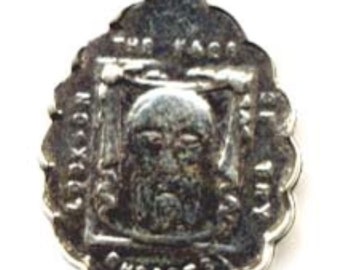 May include: Silver charm featuring a detailed image of a man's face surrounded by the words "The King of Kings" and "Christ".