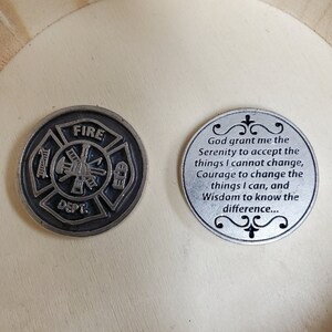 May include: Two silver-toned metal tokens. One token features a black and white fire department logo with the words "FIRE DEPT." The other token features a silver-toned inscription that reads "God grant me the Serenity to accept the things I cannot change, Courage to change the things I can, and Wisdom to know the difference..."