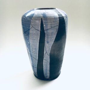Puede incluir: Un jarrón de cerámica azul y negro con un esmalte craquelado y rayas verticales.