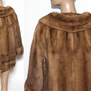 K&ouml;nnte beinhalten: Ein brauner Pelzmantel mit einem gro&szlig;en Kragen. Der Mantel ist aus weichem, luxuri&ouml;sem Pelz gefertigt und hat einen klassischen, eleganten Stil.