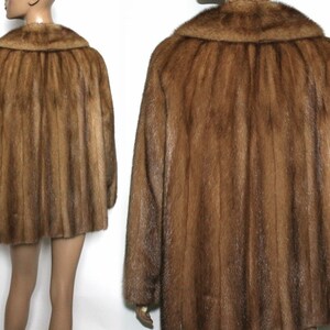 Peut inclure: Un manteau en fourrure marron avec un grand col. Le manteau est fait d'une fourrure douce et luxueuse et a un style classique et intemporel.