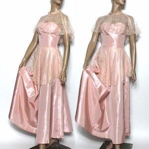 May include: A vintage pink satin and lace gown with a lace cape. The gown has a fitted bodice and a full skirt. The lace cape has a scalloped edge.