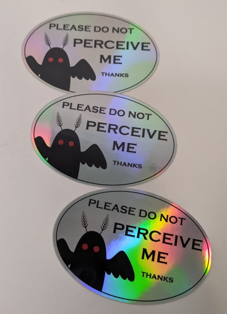 Puede incluir: Tres pegatinas hologr&aacute;ficas de forma ovalada con una ilustraci&oacute;n en blanco y negro de una criatura con ojos rojos y el texto "PLEASE DO NOT PERCEIVE ME THANKS".