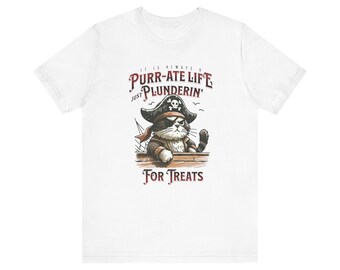 May include: White t-shirt with a cartoon pirate cat wearing an eye patch and holding a sword. The text on the shirt reads "It is always a Purr-ate Life Just Plunderin' For Treats".