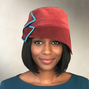 Puede incluir: Un sombrero cloche burdeos con ribete turquesa. El sombrero tiene un dise&ntilde;o angular &uacute;nico. La imagen tambi&eacute;n incluye el texto "INSTANT PDF DOWNLOAD" y "Elschen Sewing Pattern".