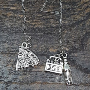 May include: A silver chain necklace with three charms: a pizza slice, a beer cooler, and a beer bottle. The charms are all detailed and have a vintage look.