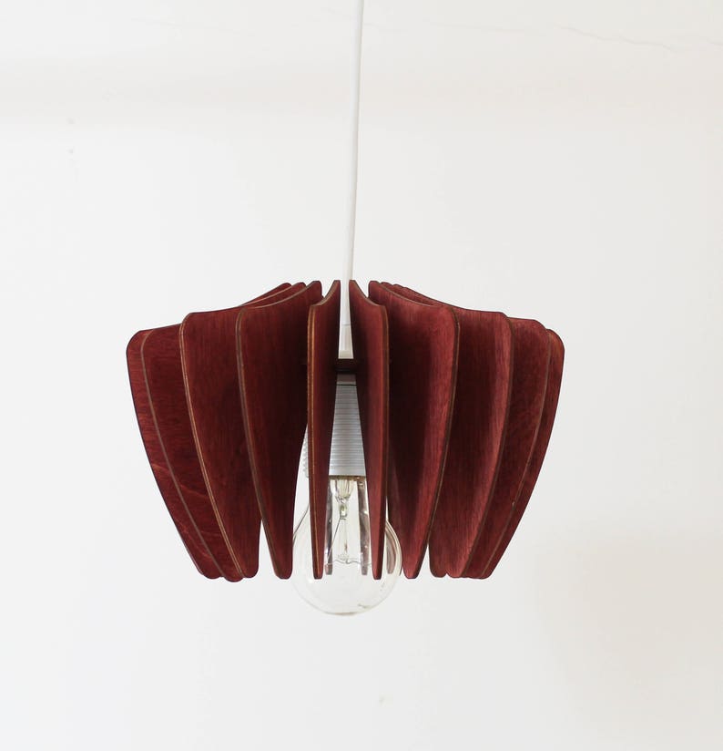 May include: A red wooden pendant light with a white cord and a clear light bulb.