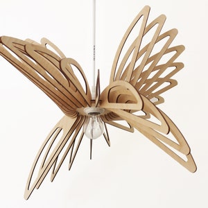 May include: A wooden pendant light fixture shaped like a butterfly with a light bulb in the center.