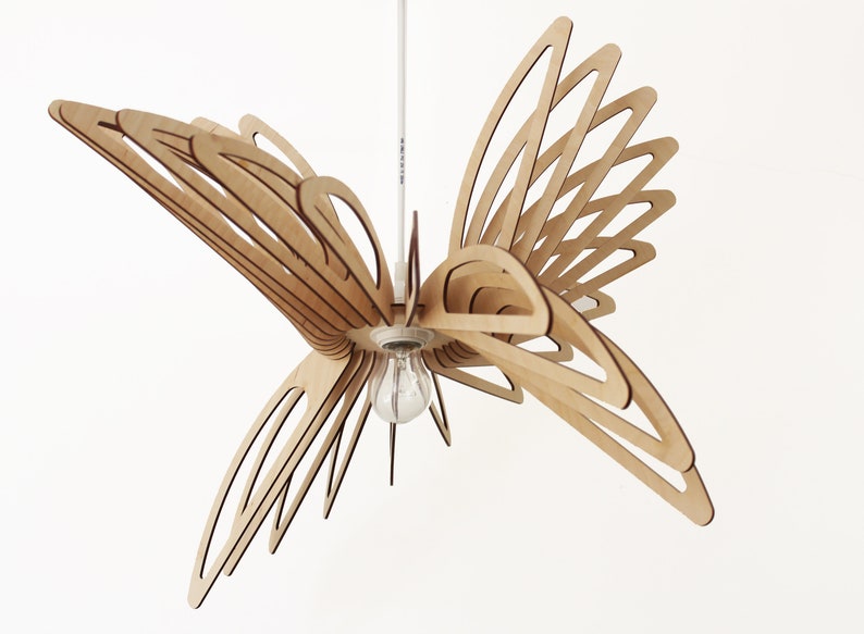 May include: A wooden pendant light fixture shaped like a butterfly with a light bulb in the center.