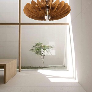 May include: A wooden ceiling light fixture with a unique, geometric design. The light fixture is made of multiple layers of wood that are cut and arranged to create a complex pattern. The light fixture is suspended from the ceiling by a single cord.