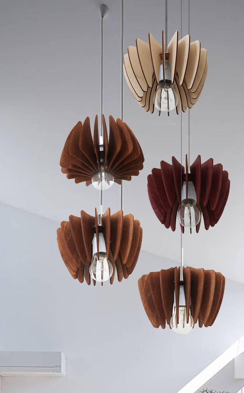 May include: Five wooden pendant lights with different shades of brown and beige. Each light has a unique shape and is suspended from a thin wire. The lights are arranged in a staggered pattern, creating a visually appealing display.