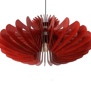May include: A red wooden pendant light fixture with a unique, geometric design. The light fixture is made of multiple layers of wood that are arranged in a spiral pattern.