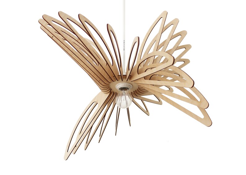 May include: A wooden pendant light fixture shaped like a stylized flower with multiple layers of thin, curved wooden pieces. The light fixture is suspended from a white cord and has a single light bulb.